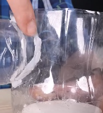 Insira um pouco (algo próximo de 1 cm) de cada extremidade da garrafa menor nos furos que você acabou de fazer nas garrafas menores, e cole vedando bem a passagem de ar ao redor do furo. Use cola quente, mas tome cuidado para não derreter as garrafas. Evite encostar o bico da cola quente nas garrafas, e tenha paciência, adicione a cola lentamente e deixe que esfrie antes de adicionar mais.