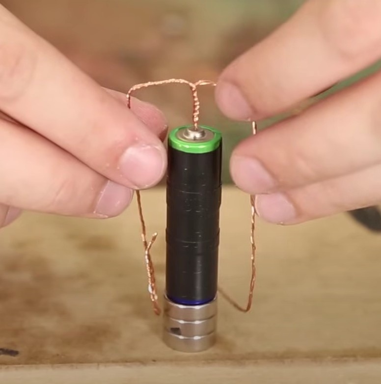 Com os fios paralelos à pilha, dobre cada fio de maneira que forme um ângulo de 90º na altura do ímã do meio. Os fios devem apontar para direções opostas.