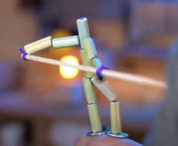 Depois de terminar o segundo lado, prenda o palito de churrasco nas “mãos” do boneco, amarrando as sobras de linha ao palito.