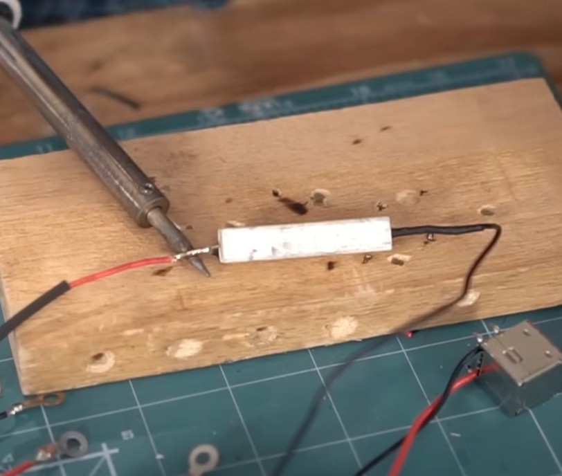 Arraste o tubinho termo retrátil até o resistor e passe o ferro de solda, com cuidado, para diminuir o diâmetro e isolar a solda. Faça este processo para os dois terminais do resistor.