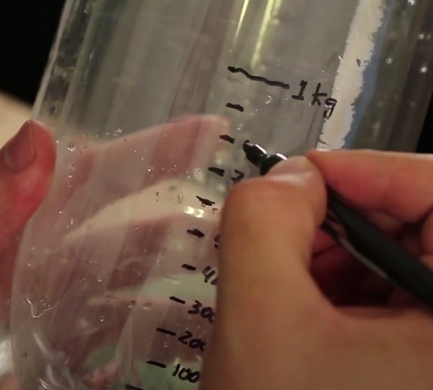 Para fazer a gradação de 100 em 100g, use a régua para medir a distância entre o 0 e 1kg. Divida esta distância por 10.  Faça a marcação de 100g, 200g....até 900g. Assim teremos concluído a calibração da balança.