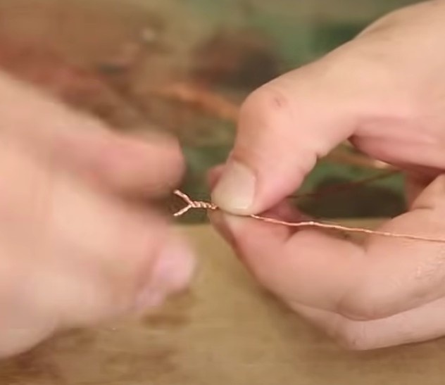 Coloque um fio ao lado do outro e enrole entre si apenas as partes marcadas. É importante que fique bem enrolada e presa.