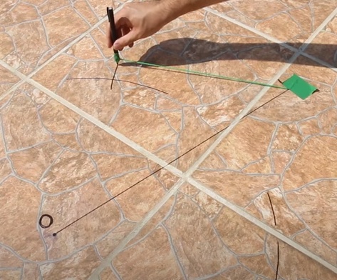 Utilize um esquadro para desenhar uma linha perpendicular à linha leste/oeste, e está será a linha norte/sul.

a. Caso não tenho um esquadro disponível ou prefira usar outros métodos, é possível encontrar esta reta utilizando o mesmo fio usado anteriormente para desenhar o semicírculo, e realize procedimento semelhante, fixando uma ponta da linha ao primeiro ponto de sombra marcado, e fazendo outro semicírculo em direção ao outro ponto, depois repita o processo com a linha fixada ao segundo ponto, e o semicírculo apontado para o primeiro ponto. 

b. Esses semicírculos então terão dois pontos de contato entre eles, trace uma reta e uma intersecção até a outra, e então esta será a linha norte/sul.