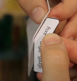 Para corrigir o ângulo das dobras da frente do planador, utilize a peça “front angle gauge”, apoiando ela por baixo do planador e aumentando ou reduzindo a angulação da dobra até que se encaixe perfeitamente a peça.