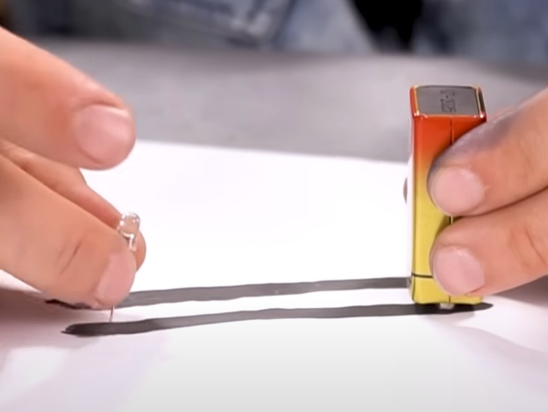 Encontre os polos positivo e negativo da bateria e encoste um deles em uma linha e o outro em outra. NÃO COLOQUE NA MESMA LINHA.