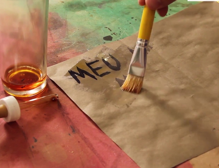 Utilizando um pincel, passe essa mistura meio marrom pelo papel! Assim você vai revelar a mensagem que estava escrita. A mensagem aparecerá em um tom escuro, entre o roxo e azul.