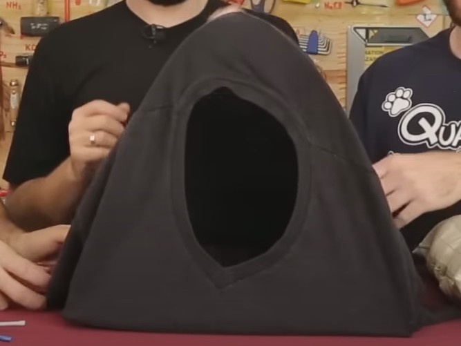 Com a camiseta, vista toda a estrutura, deixando a gola da camiseta em uma das laterais. Este será o ponto de entrada da toca. Deixe as mangas da camisetas próximas a base da toca, isso vai ajudar a prende-las com os alfinetes.