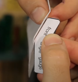 Para corrigir o ângulo das dobras da frente do planador, utilize a peça “front angle gauge”, apoiando ela por baixo do planador e aumentando ou reduzindo a angulação da dobra até que se encaixe perfeitamente a peça.